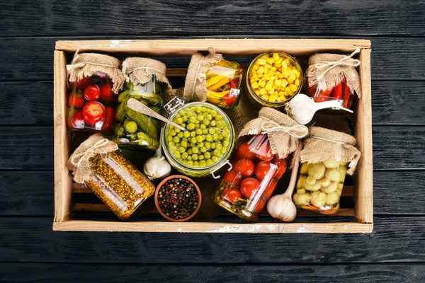 Pickled foods in cans. Stocks of food. Top view. On a wooden background. Copy space.
