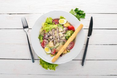 Sığır eti ile Sezar salatası. Beyaz ahşap zemin üzerinde. Üstten Görünüm. Metniniz için kopya alanı.