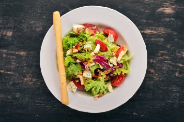 Peynir, fındık ve taze sebze salatası. Ahşap bir arka plan üzerinde. Üstten Görünüm. Metniniz için kopya alanı.