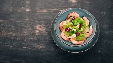 Kraliyet karides krem sos ve peynir. Bir plaka üzerinde deniz ürünleri. Üstten Görünüm. Siyah ahşap arka plan üzerinde. Kopya alanı.