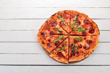 Biber ve salamlı pizza. Üstten Görünüm. Ahşap bir arka plan üzerinde. Kopya alanı.