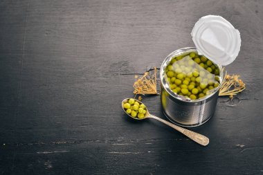 Bir kavanoz turşu yeşil bezelye. Gıda stokları. Üstten Görünüm. Ahşap bir arka plan üzerinde. Kopya alanı.