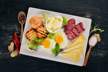 Kahvaltı. Pastırma ve domates, kızarmış ekmek ekmek ile yumurta. Üstten Görünüm. Ahşap bir arka plan üzerinde. Kopya alanı.