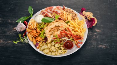 Aperatifler bira için bir seçim. Cips, sosis, peynir. Üstten Görünüm. Ahşap bir arka plan üzerinde. Kopya alanı.