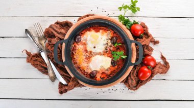 Sebze ve parmesan peyniri ile bir tavada kızarmış yumurta kızarmış. Ahşap bir arka plan üzerinde. Üstten Görünüm. Kopya alanı.