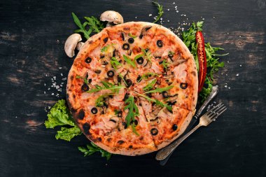 Pizza capricciosa. Mozzarella peyniri, jambon, mantar, zeytin. Üstten Görünüm. Ahşap bir arka plan üzerinde. Kopya alanı.