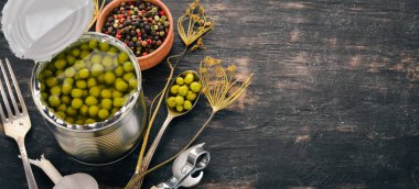 Bir kavanoz turşu yeşil bezelye. Gıda stokları. Üstten Görünüm. Ahşap bir arka plan üzerinde. Kopya alanı.