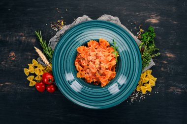 Farfalle makarna domates ve parmesan peyniri. Ahşap bir arka plan üzerinde. İtalyan mutfağı. Üstten Görünüm. Kopya alanı.