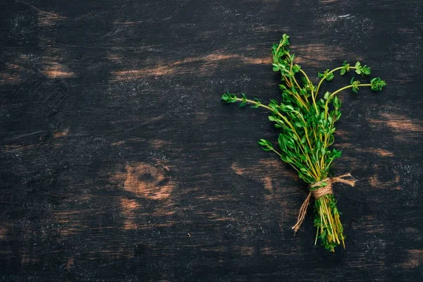 Tymyan ve biberiye. Siyah ahşap arka plan üzerinde. Baharat üstten görünüm. Kopya alanı.