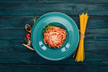 Domatesli makarna makarna. Ahşap bir arka plan üzerinde. İtalyan mutfağı. Üstten Görünüm. Kopya alanı.
