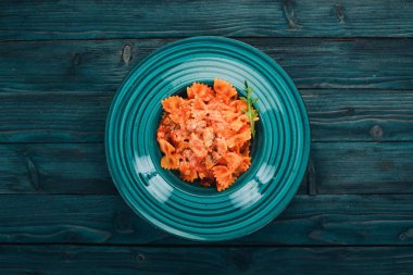 Farfalle makarna domates ve parmesan peyniri. Ahşap bir arka plan üzerinde. İtalyan mutfağı. Üstten Görünüm. Kopya alanı.