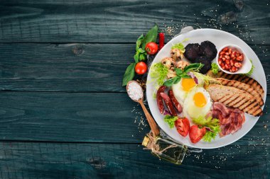 Kahvaltı. Pastırma ve domates, kızarmış ekmek ekmek ile yumurta. Üstten Görünüm. Ahşap bir arka plan üzerinde. Kopya alanı.