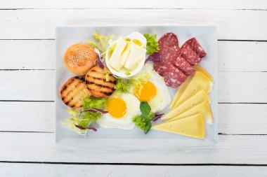 Kahvaltı. Pastırma ve domates, kızarmış ekmek ekmek ile yumurta. Üstten Görünüm. Ahşap bir arka plan üzerinde. Kopya alanı.