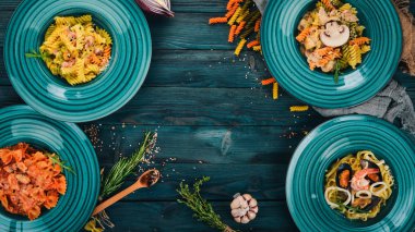 Tabak pişmiş macunlar kümesi. Ahşap bir arka plan üzerinde. İtalyan mutfağı. Üstten Görünüm. Kopya alanı.