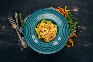 Carbonara pastırma ile makarna. Ahşap bir arka plan üzerinde. İtalyan mutfağı. Üstten Görünüm. Kopya alanı.