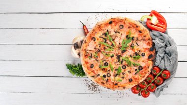 Pizza capricciosa. Mozzarella peyniri, jambon, mantar, zeytin. Üstten Görünüm. Ahşap bir arka plan üzerinde. Kopya alanı.
