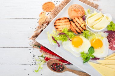 Kahvaltı. Pastırma ve domates, kızarmış ekmek ekmek ile yumurta. Üstten Görünüm. Ahşap bir arka plan üzerinde. Kopya alanı.