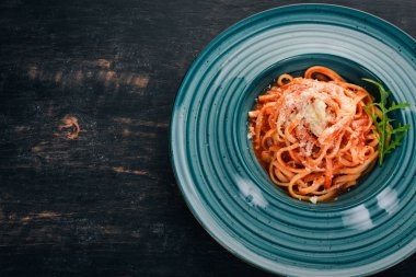 Domatesli makarna makarna. Ahşap bir arka plan üzerinde. İtalyan mutfağı. Üstten Görünüm. Kopya alanı.