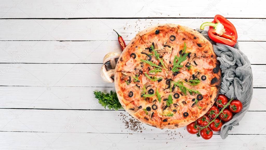 Pizza capricciosa. Mozzarella, ham, mushrooms, olives. Top view. On a wooden background. Copy space.