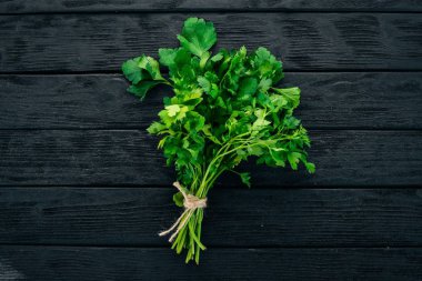 Taze maydanoz. Siyah ahşap arka plan üzerinde. Sağlıklı gıda. Üstten Görünüm. Kopya alanı.