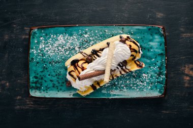 Muz ve krema ile dondurma. Siyah ahşap arka plan üzerinde. Kopya alanı.