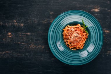 Domatesli makarna makarna. Ahşap bir arka plan üzerinde. İtalyan mutfağı. Üstten Görünüm. Kopya alanı.