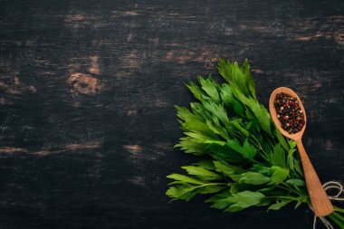 Biber ve kereviz yaprakları. Ahşap bir arka plan üzerinde. Üstten Görünüm. Kopya alanı.