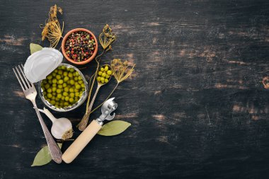 Bir kavanoz turşu yeşil bezelye. Gıda stokları. Üstten Görünüm. Ahşap bir arka plan üzerinde. Kopya alanı.