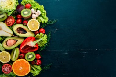 Sağlıklı gıda. Sebze ve meyveler siyah ahşap zemin. Üstten Görünüm. Kopya alanı.