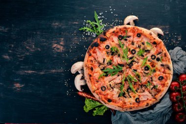 Pizza capricciosa. Mozzarella peyniri, jambon, mantar, zeytin. Üstten Görünüm. Ahşap bir arka plan üzerinde. Kopya alanı.