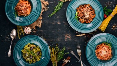 Tabak pişmiş macunlar kümesi. Ahşap bir arka plan üzerinde. İtalyan mutfağı. Üstten Görünüm. Kopya alanı.