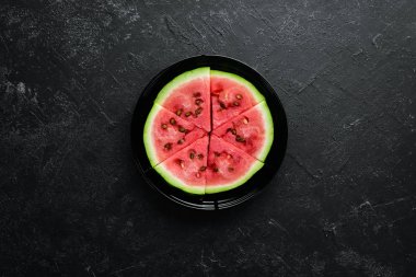 Siyah arka planda karpuz dondurması. Çubuklarda karpuz dilimleri. Üst Manzara. Boş kopyalama alanı.