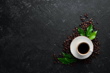 Bir fincan kokulu sade kahve. Siyah taştan bir arka planda. Üst Manzara. Metnin için boş yer.