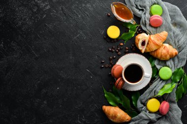 Kurabiyeli bir fincan kahve. Siyah taştan bir arka planda. Üst Manzara. Metnin için boş yer.