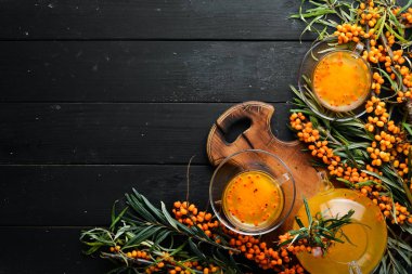 Sıcak deniz karabatağı çayı. Dal üzerinde taze deniz dikenleri. Üst Manzara. Metnin için boş yer.