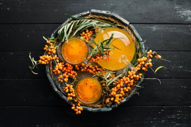 Deniz dikenli üzümlerden iç. Sıcak kış içeceği. Dal üzerinde taze deniz dikenleri. Üst Manzara. Metnin için boş yer.