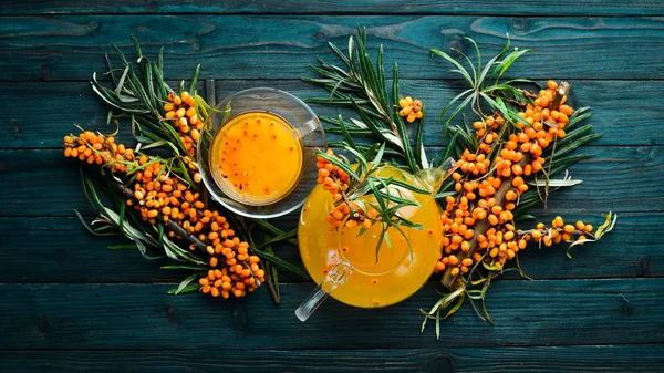 Drink from sea buckthorn berries. Winter hot drink. Fresh sea buckthorn on a twig. Top view. Free space for your text.