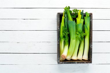 Siyah taştan bir arka planda tahta bir kutuda taze pırasa. Üst Manzara. Boş kopyalama alanı.