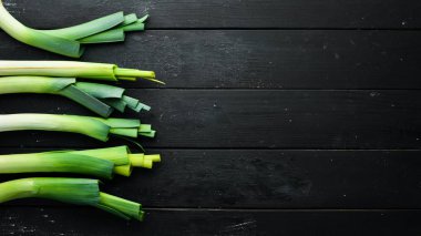 Siyah arka planda çiğ yeşil pırasa. Sağlıklı yemek için sebzeler. Üst Manzara. Boş kopyalama alanı.