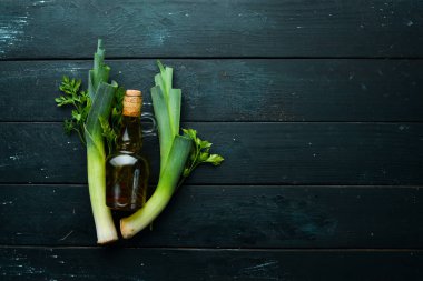 Siyah arka planda pırasa, maydanoz ve yağ. Sağlıklı yemek için sebzeler. Üst Manzara. Boş kopyalama alanı.