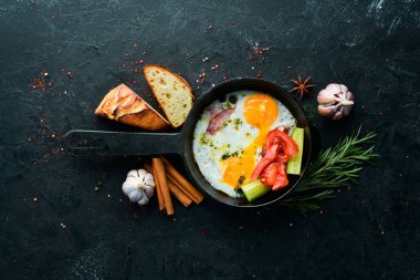 Kahvaltıda. Kızartma tavasında domuz pastırması ve sebzeli yumurta. Üst Manzara. Boş kopyalama alanı.