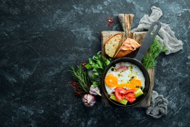 Kahvaltıda. Kızartma tavasında domuz pastırması ve sebzeli yumurta. Üst Manzara. Boş kopyalama alanı.
