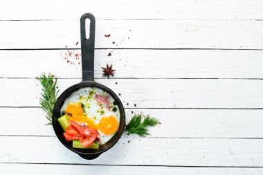 Kahvaltıda. Kızartma tavasında domuz pastırması ve sebzeli yumurta. Üst Manzara. Boş kopyalama alanı.