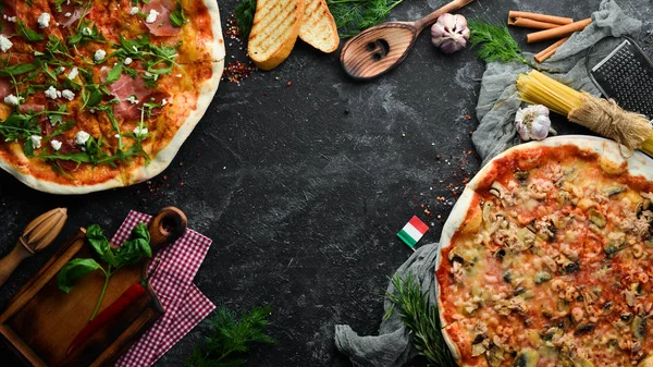 Pizza background. Assortment of pizza and ingredients. Italian traditional cuisine. Top view. Free copy space.