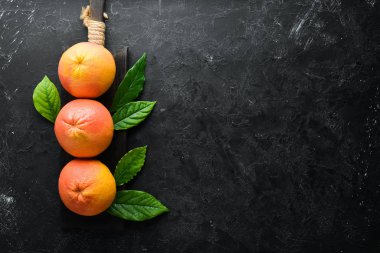 Yapraklı taze greyfurt. Beyaz ahşap arka planda turunçgil meyveleri. Üst Manzara. Boş kopyalama alanı.