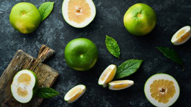 Sweetie green citrus fruit. On a black stone background. Top view. Free copy space. clipart