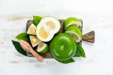 Sweetie green citrus fruit. On a black stone background. Top view. Free copy space. clipart