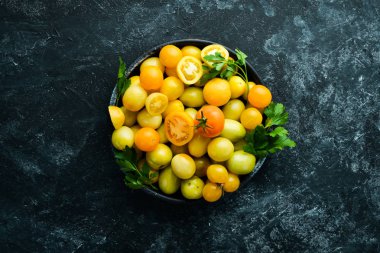 Siyah taş zemin üzerinde sarı domatesler. Üst Manzara. Metnin için boş yer.