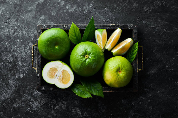 Sweetie green citrus fruit in wooden box.Top view.