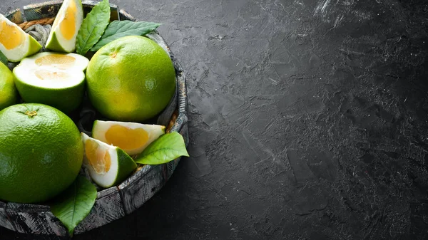 Lieverd Groene Citrusvruchten Een Zwarte Stenen Achtergrond Bovenaanzicht Gratis Kopieerruimte — Stockfoto